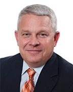 Portrait of Douglas L. DeBusk, Executive Vice President and Chief Lending Officer of Andrew Johnson Bank, presenting a professional and approachable demeanor.